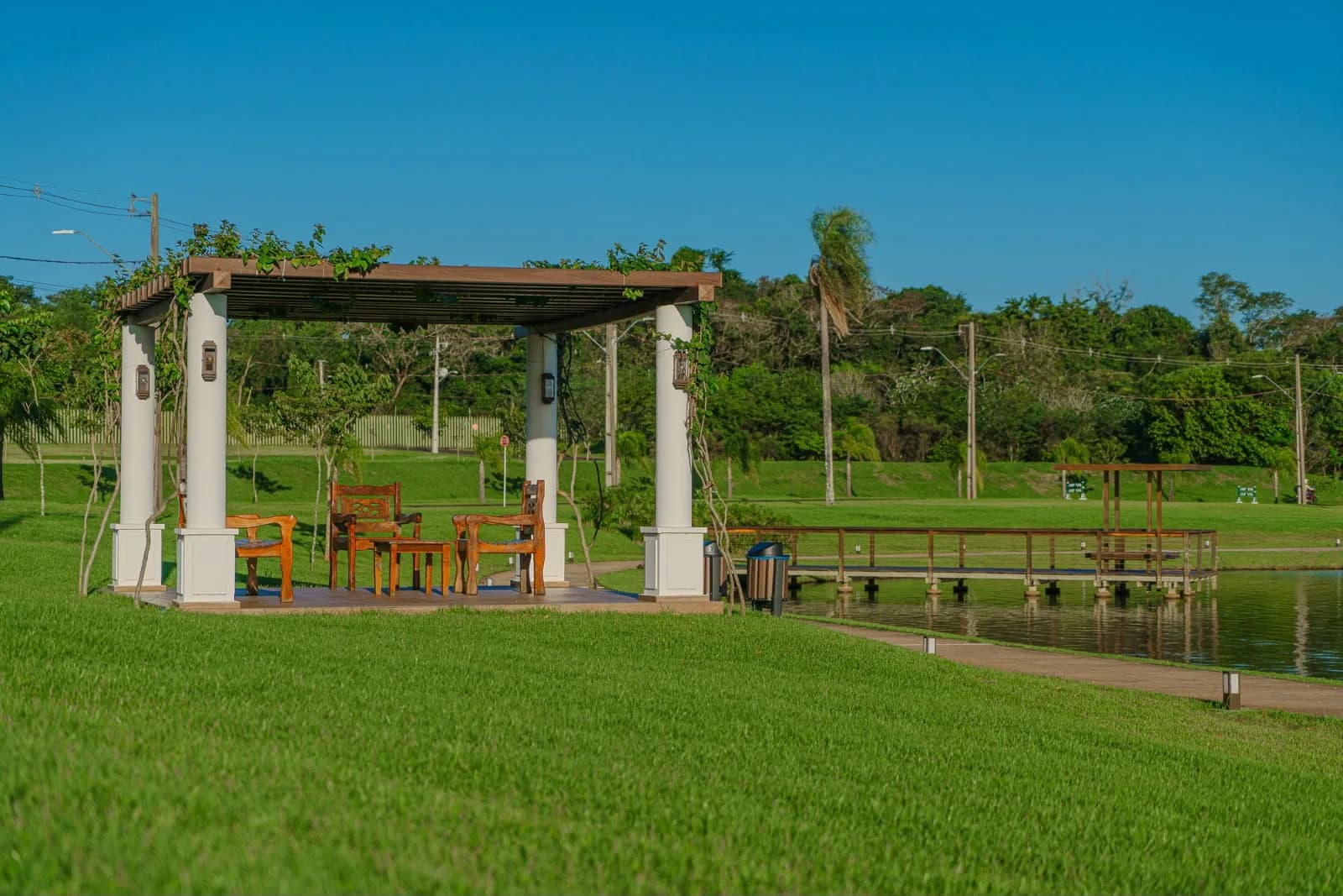 Pérgola com trepadeiras e píer sobre o lago